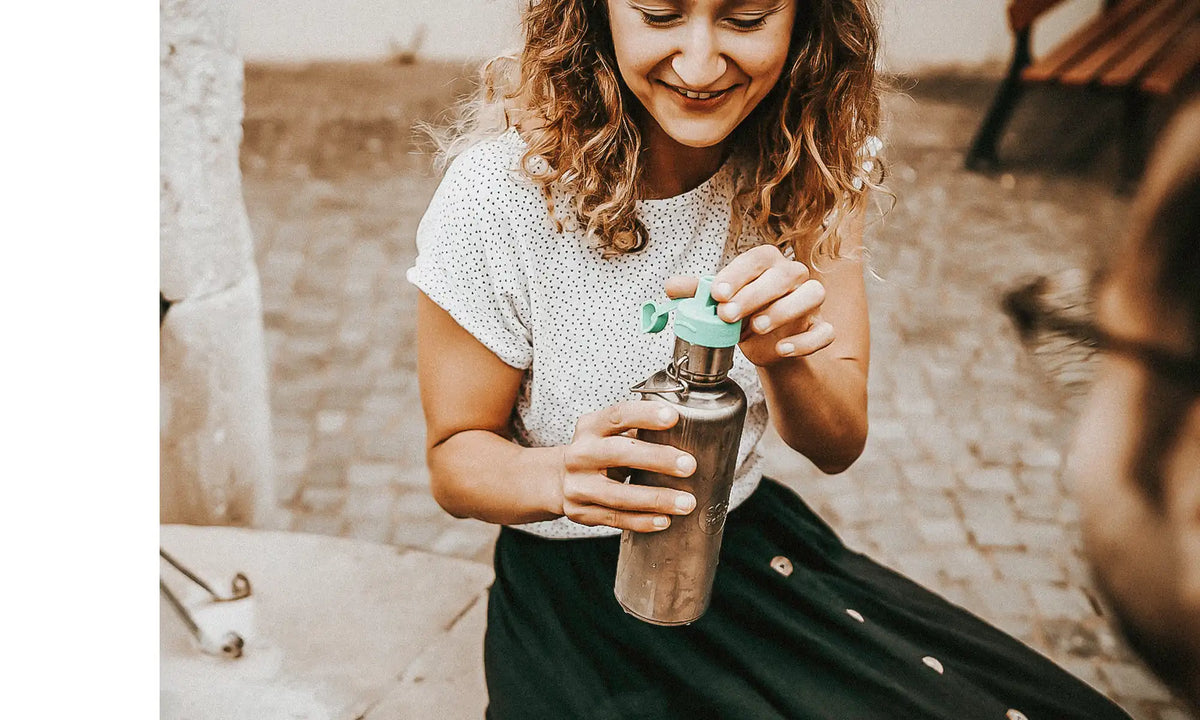 Frau mit Trinkflasche aus Edelstahl mit Wasserfilter in der Stadt